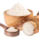 Arrowroot powder in a wooden bowl and spoon with fresh arrowroot root