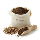 Chicory powder in burlap sack with chicory root pieces and wooden scoop on white background