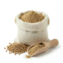 Coriander seed powder in burlap sack with whole seeds and wooden scoop on white background