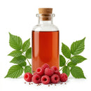Red raspberry seed oil in glass bottle with raspberries and green leaves on white background