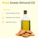 Clear glass bottle of pure sweet almond oil with whole almonds and usage benefits