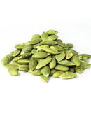 Pile of raw green pumpkin seeds on white background